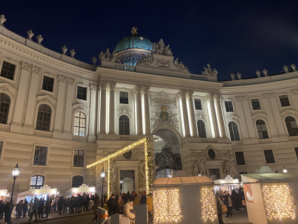 Front of the Hofburg palace and christmas stalls at the Michaelerplatz square, by night