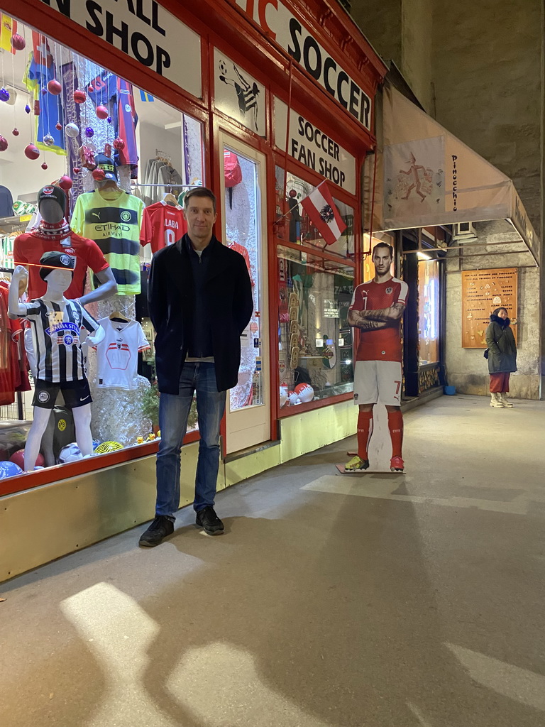 Tim in front of the Soccer Fan Shop at the Augustinerstraße street, by night