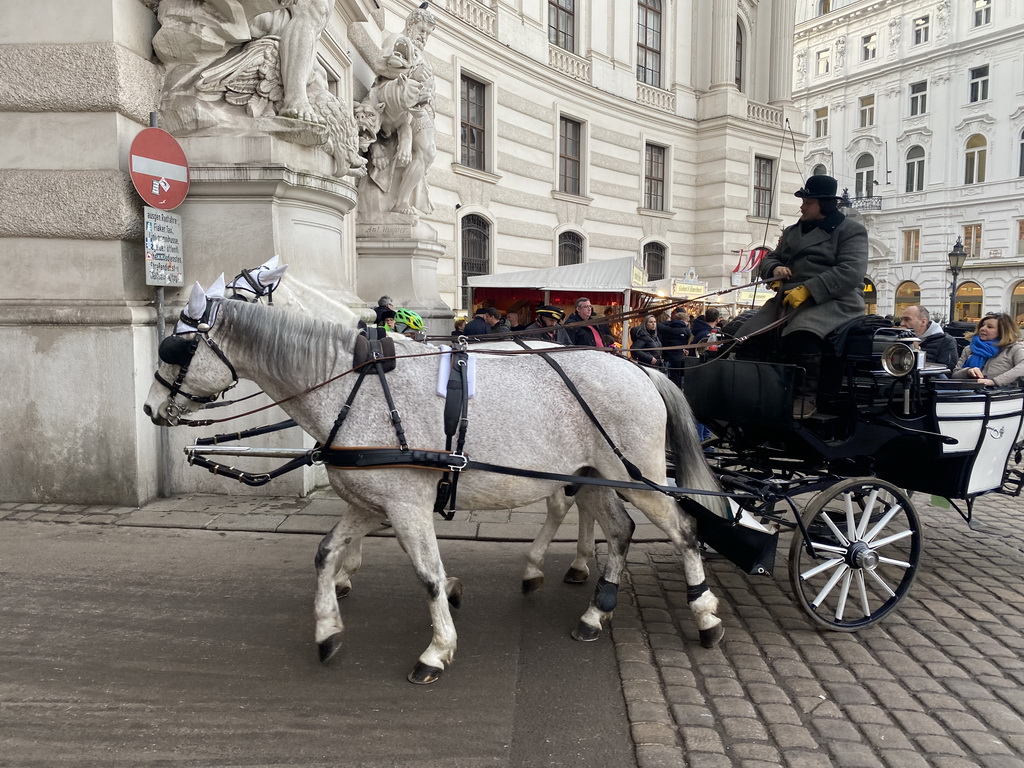 Horses and carriage entering the In Der Burg courtyard of the Hofburg palace from the Michaelerplatz square