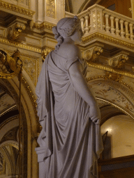 Statue at the upper floor of the Wiener Staatsoper building, with a view on the Grand Staircase