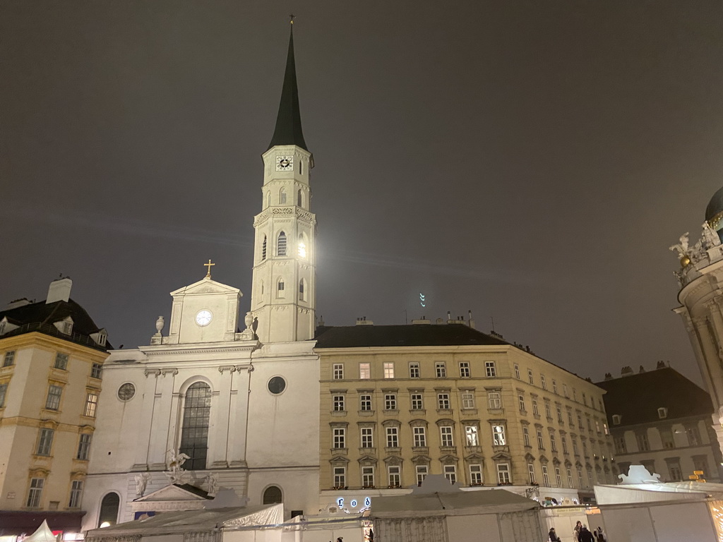 Front of St. Michael`s Church and christmas stalls at the Michaelerplatz square, by night