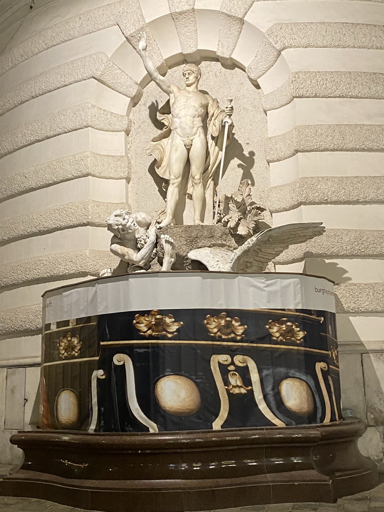 Fountain in front of the Hofburg palace at the Michaelerplatz square, under renovation, by night