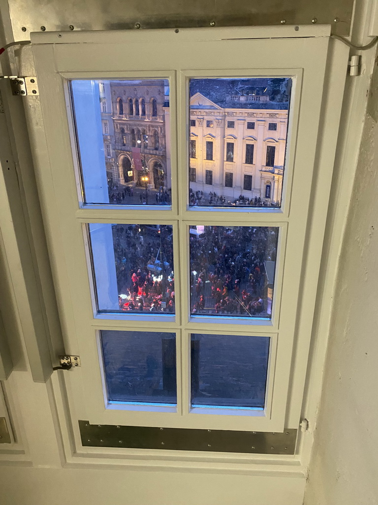 Window at the staircase from the third to the fourth floor of the Benediktushaus im Schottenstift hotel, with a view on the Silvesterpfad festivities at the Freyung square, at sunset