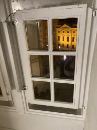 Window at the staircase from the third to the fourth floor of the Benediktushaus im Schottenstift hotel, with a view on the Silvesterpfad festivities at the Freyung square, by night