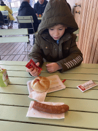 Max eating a Käsekrainer at the kiosk at the petting zoo at the Schönbrunn Zoo