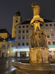 Austriabrunnen fountain and the front of the Benediktushaus im Schottenstift hotel at the Freyung square, by night