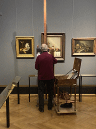 Painter recreating the painting `Still life with Nautilus cup and ginger pot` by Juriaen van Streeck at Room 19 of the Picture Gallery at the first floor of the Kunsthistorisches Museum Wien