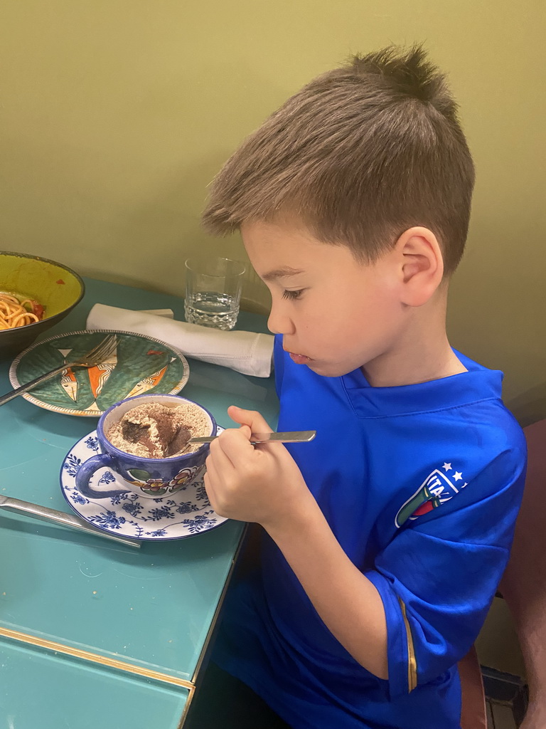 Max eating tiramisu at the Ristorante Evu` restaurant
