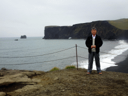 Miaomiao`s father at the lower viewpoint of the Dyrhólaey peninsula, with a view on the Rock Arch