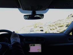 Miaomiao driving the rental car on the TF-21 road, with a view on a sign of the Teide National Park