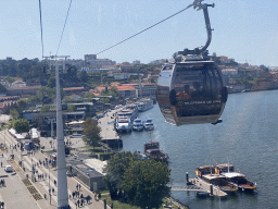 Boats on the Douro river and the Avenida de Ramos Pinto street with the Gaia Cable Car building, viewed from the Gaia Cable Car