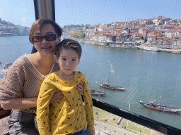 Miaomiao and Max at the Gaia Cable Car, with a view on boats on the Douro river and Porto with the Cais da Estiva street