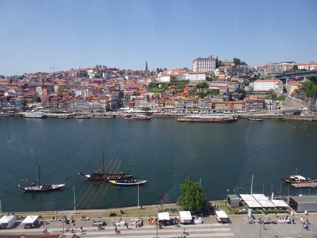 Boats on the Douro river and Porto with the Cais da Estiva and Cais da Ribeira streets, the Capela de Nossa Senhora do Ó chapel, the Mercado Ferreira Borges market, the Igreja de Nossa Senhora da Vitória church, the Torre dos Clérigos tower, the Igreja dos Grilos church and the Paço Episcopal do Porto palace, viewed from the Gaia Cable Car