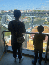 Miaomiao and Max at a viewing point at the Gaia Cable Car building at the Jardim do Morro park, with a view on the Muralha Fernandina wall and the Ponte Luís I bridge over the Douro river