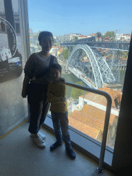 Miaomiao and Max at a viewing point at the Gaia Cable Car building at the Jardim do Morro park, with a view on the Muralha Fernandina wall and the Ponte Luís I bridge over the Douro river