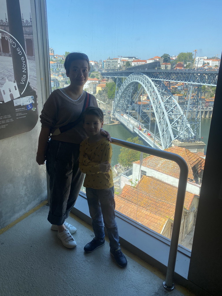 Miaomiao and Max at a viewing point at the Gaia Cable Car building at the Jardim do Morro park, with a view on the Muralha Fernandina wall and the Ponte Luís I bridge over the Douro river