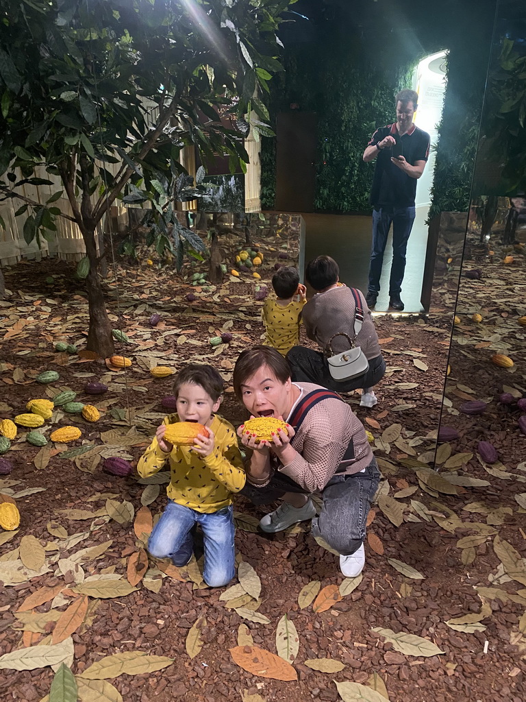 Miaomiao and Max with fake cacao fruits and cacao trees at the Chocolate Story museum at the WOW Cultural District
