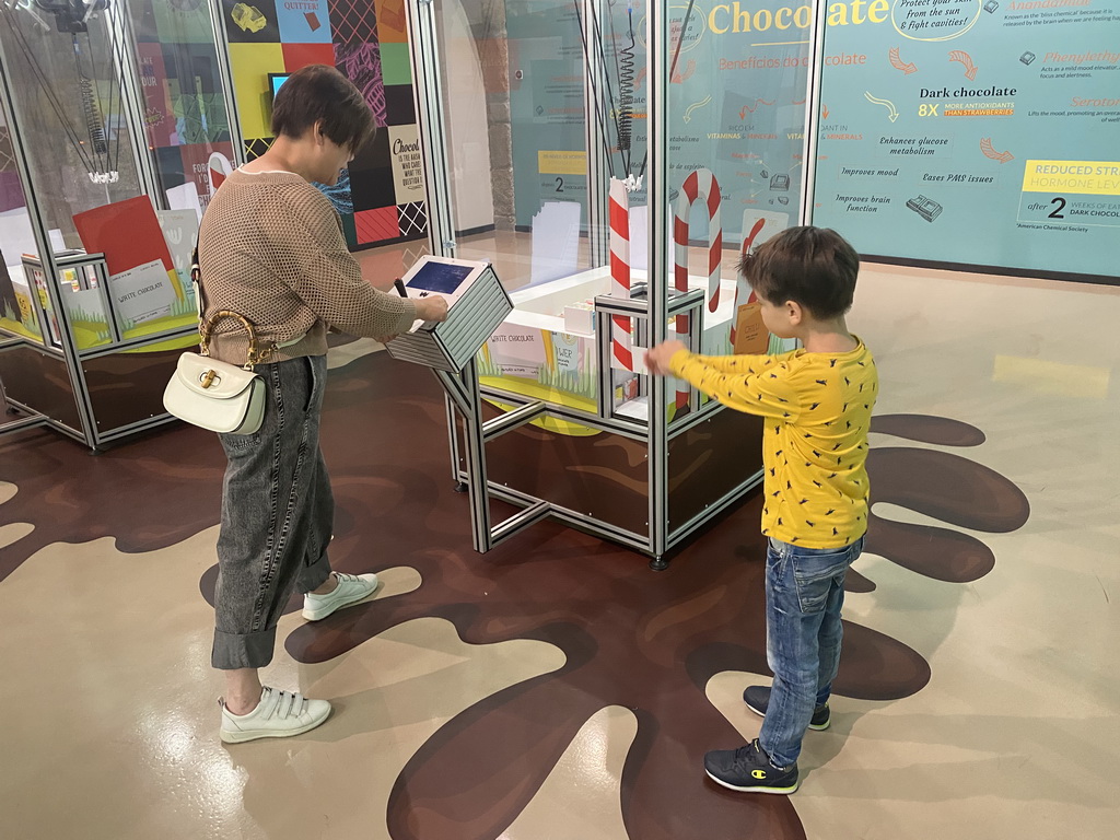 Miaomiao and Max with a chocolate grab machine at the Chocolate Factory section at the Chocolate Story museum at the WOW Cultural District