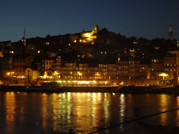 Boats on the Douro river and Porto with the Cais da Ribeira street, the Igreja de Nossa Senhora da Vitória church and the Torre dos Clérigos tower and the Paço Episcopal do Porto palace, viewed from the Avenida de Diogo Leite street, by night