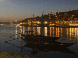 Boats and the Ponte da Arrábida bridge over the Douro river and the west side of Porto, viewed from the Avenida de Diogo Leite street, by night