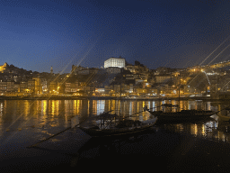 Boats and the Ponte Luís I bridge over the Douro river and Porto with the Cais da Ribeira street, the Torre dos Clérigos tower and the Paço Episcopal do Porto palace, viewed from the Avenida de Diogo Leite street, by night