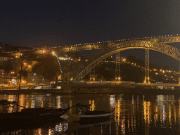 Boats and the Ponte Luís I bridge over the Douro river, viewed from the Avenida de Diogo Leite street, by night