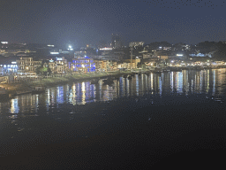 Boats on the Douro river and the Avenida de Diogo Leite street, viewed from the lower level of the Ponte Luís I bridge, by night