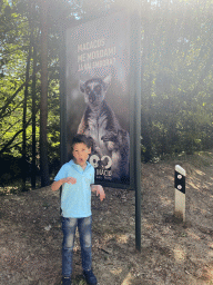 Max with a sign with a photo of a Ring-tailed Lemur at the entrance road to the Zoo Santo Inácio