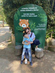 Miaomiao and Max at a sign with a Red Panda at the Zoo Santo Inácio