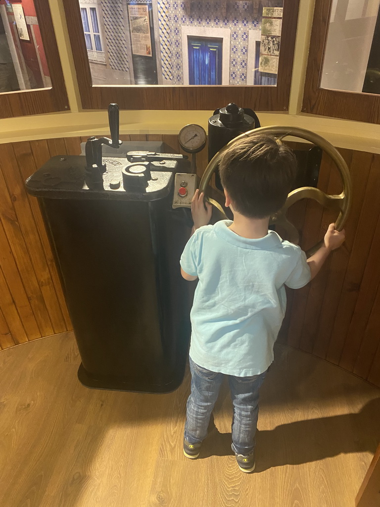 Max at the steering wheel of a tram at the Porto Region Across the Ages museum at the WOW Cultural District