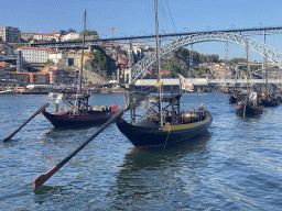 Boats and the Ponte Luís I bridge over the Douro river and Porto with the Muralha Fernandina wall, viewed from the ferry dock