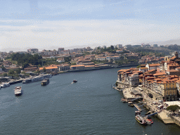 Boats over the Douro river and Porto with the Cais da Estiva street, viewed from the subway train on the Ponte Luís I bridge