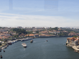 Boats over the Douro river and Porto with the Cais da Estiva street, viewed from the subway train on the Ponte Luís I bridge