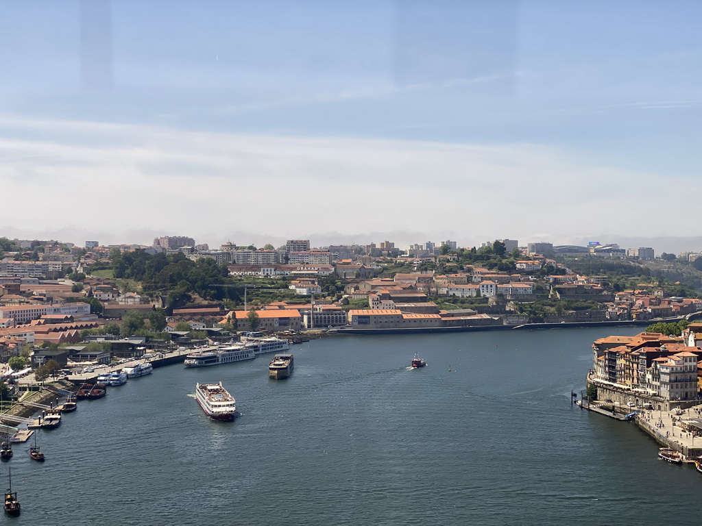 Boats over the Douro river and Porto with the Cais da Estiva street, viewed from the subway train on the Ponte Luís I bridge