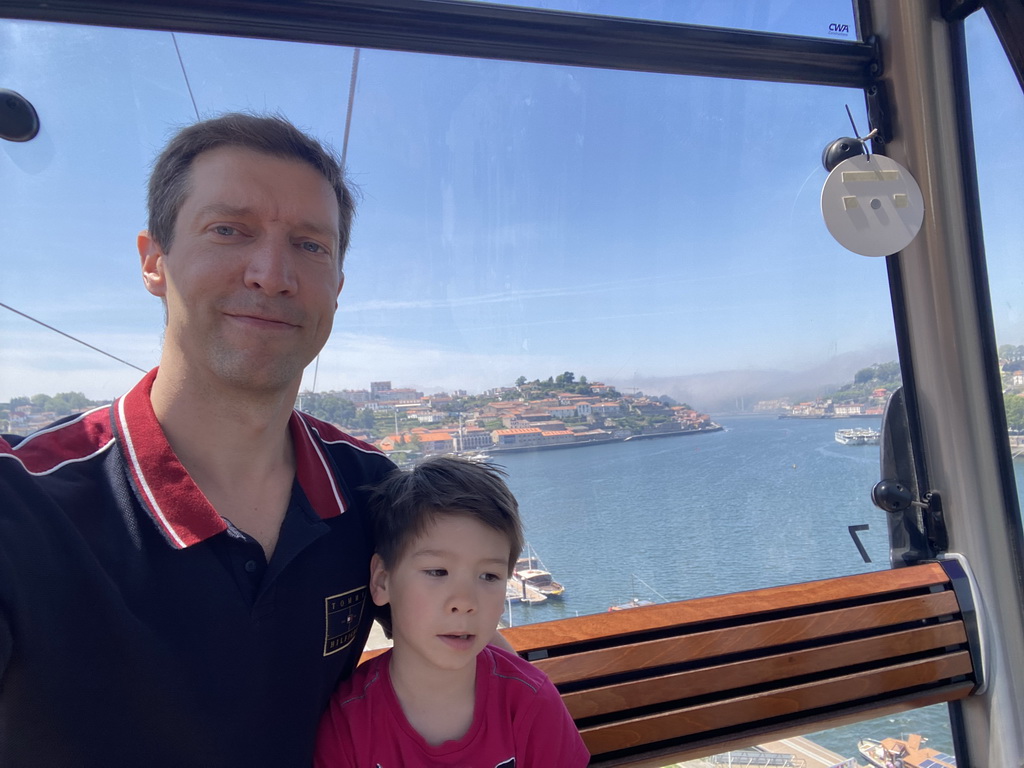 Tim and Max at the Gaia Cable Car, with a view on boats and the Ponte da Arrábida bridge over the Douro river