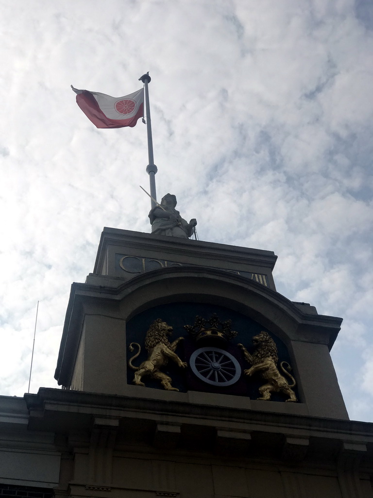 Relief, statue and flag on top of the northeast side of the City Hall at the Markt square