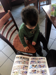 Max reading a Donald Duck comic at Cafetaria `t Passantje at the Kapelstraat street