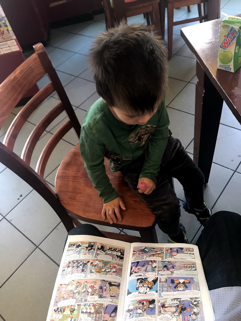Max reading a Donald Duck comic at Cafetaria `t Passantje at the Kapelstraat street