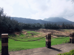 Grassfield, lake, trees and mountains, viewed from the touring car at the Xinglong Tropical Garden