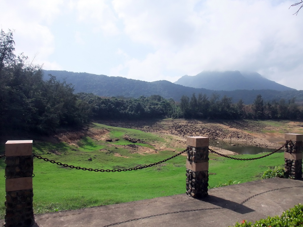 Grassfield, lake, trees and mountains, viewed from the touring car at the Xinglong Tropical Garden