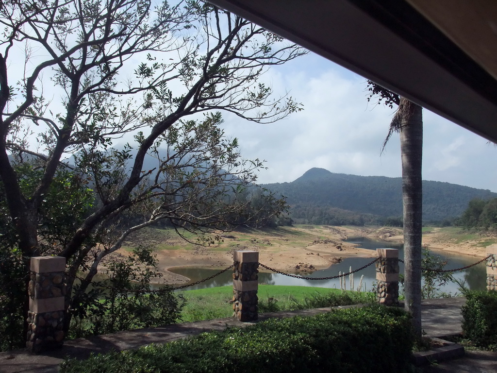 Grassfield, lake, trees and mountains, viewed from the touring car at the Xinglong Tropical Garden