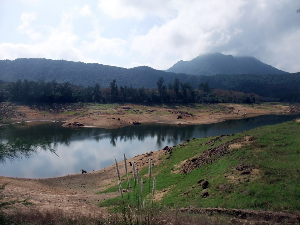 Grassfield, lake, trees and mountains, viewed from the Xinglong Tropical Garden