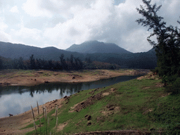 Grassfield, lake, trees and mountains, viewed from the Xinglong Tropical Garden