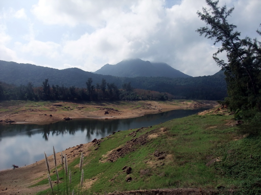 Grassfield, lake, trees and mountains, viewed from the Xinglong Tropical Garden