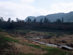 Grassland, river, trees and hills, viewed from the Xinglong Tropical Garden