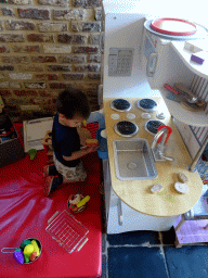 Max playing with a toy kitchen at the Le Bivouac de l`Empereur restaurant