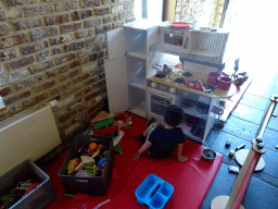 Max playing with a toy kitchen at the Le Bivouac de l`Empereur restaurant