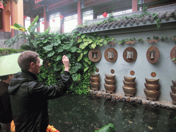 Tim throwing a coin at the buddhist bells at the Yuchan Palace at the Hainan Wenbifeng Taoism Park