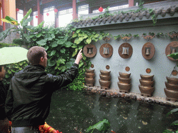 Tim throwing a coin at the buddhist bells at the Yuchan Palace at the Hainan Wenbifeng Taoism Park