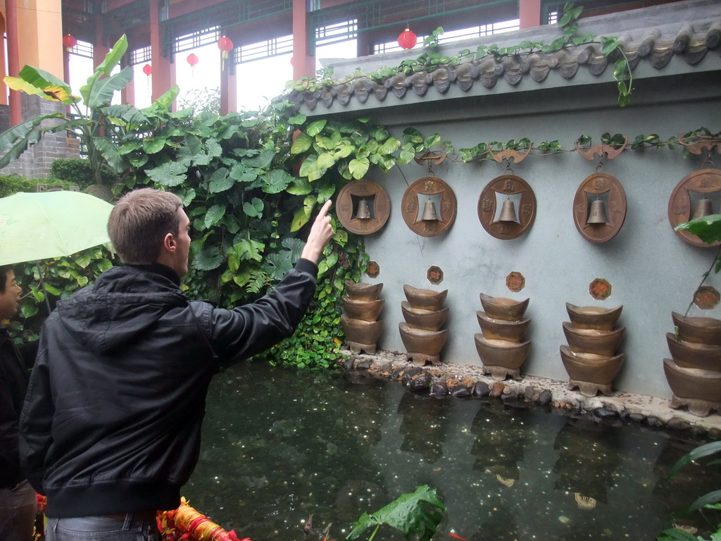 Tim throwing a coin at the buddhist bells at the Yuchan Palace at the Hainan Wenbifeng Taoism Park